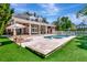 Luxury home exterior featuring backyard pool, spa, patio, and lush lawn and landscaping at 29540 Chapel Park Dr, Wesley Chapel, FL 33543