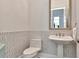 Powder room with decorative tile walls, pedestal sink, and framed mirror at 29540 Chapel Park Dr, Wesley Chapel, FL 33543