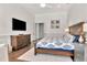 Cozy bedroom with a wooden bed frame, stylish dresser, flat-screen TV, and a comfortable rug at 29540 Chapel Park Dr, Wesley Chapel, FL 33543