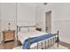 Bright bedroom with white trim, wood floors, metal frame bed, nightstands and paneled walls at 29540 Chapel Park Dr, Wesley Chapel, FL 33543