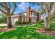 Brick home featuring a manicured lawn, landscaping, and a three-car garage at 29540 Chapel Park Dr, Wesley Chapel, FL 33543