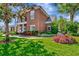 Angled exterior shows manicured flower beds and mature trees surrounding brick home at 29540 Chapel Park Dr, Wesley Chapel, FL 33543