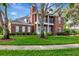 Charming brick home with lush green lawn and mature trees offering shade at 29540 Chapel Park Dr, Wesley Chapel, FL 33543