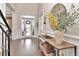 A grand foyer welcomes guests with a decorative mirror, wooden console table, and hardwood floors at 29540 Chapel Park Dr, Wesley Chapel, FL 33543