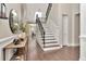 Entryway featuring a staircase with iron railings, hardwood floors, stylish console table and decorative mirror at 29540 Chapel Park Dr, Wesley Chapel, FL 33543