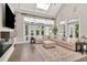 Bright open-plan living room featuring a fireplace, large windows, vaulted ceiling and a comfy sectional sofa at 29540 Chapel Park Dr, Wesley Chapel, FL 33543