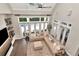 Bright living room with hardwood floors, large windows, and a sectional sofa at 29540 Chapel Park Dr, Wesley Chapel, FL 33543