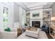 Cozy living room with a fireplace, built-in shelves, stylish armchairs and patterned drapery at 29540 Chapel Park Dr, Wesley Chapel, FL 33543