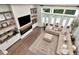 Bright living room with large windows overlooking pool, built-in shelves, fireplace and tan colored sectional sofa at 29540 Chapel Park Dr, Wesley Chapel, FL 33543