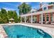 Beautiful backyard pool and spa with outdoor kitchen and covered seating area, perfect for entertaining at 29540 Chapel Park Dr, Wesley Chapel, FL 33543