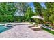 Lounge chairs beside a lushly landscaped in-ground pool with a hot tub at 29540 Chapel Park Dr, Wesley Chapel, FL 33543