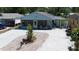 This home includes a covered porch with furniture, manicured landscaping, and a large, paved driveway at 3105 Gordon Ct, Tampa, FL 33619
