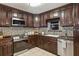 Modern kitchen featuring dark wood cabinets, granite countertops, stainless steel appliances and tiled backsplash at 3105 Gordon Ct, Tampa, FL 33619