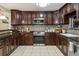 Modern kitchen featuring dark wood cabinets, granite countertops, stainless steel appliances and tiled backsplash at 3105 Gordon Ct, Tampa, FL 33619