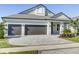 Wide driveway leading to a three-car garage, complemented by a manicured lawn and landscaping at 324 3Rd N Ave, Safety Harbor, FL 34695