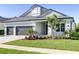 Beautiful home exterior showcasing a well-manicured lawn, lush landscaping, and a three-car garage at 324 3Rd N Ave, Safety Harbor, FL 34695