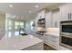 Bright kitchen featuring an island with sink, modern appliances, and sleek white cabinets at 324 3Rd N Ave, Safety Harbor, FL 34695