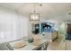 Open dining area with modern light fixture and view of the open-concept living area at 3675 41St S Way # K, St Petersburg, FL 33711