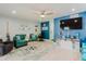 Bright living room with coastal decor, teal couch, and ceiling fan at 3675 41St S Way # K, St Petersburg, FL 33711