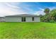 Lush backyard featuring a new home with sliding glass doors and ample space for outdoor activities at 3879 E Price Blvd, North Port, FL 34288