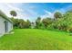 Expansive backyard, ready for personalization, is surrounded by tropical foliage, offering a private oasis at 3879 E Price Blvd, North Port, FL 34288