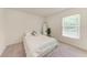 Neutrally decorated bedroom with plush carpet, white bedding, and a bright window at 3879 E Price Blvd, North Port, FL 34288