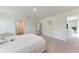 Bright bedroom featuring a plush white bed, neutral carpet, and a door leading to another room at 3879 E Price Blvd, North Port, FL 34288