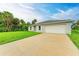 Charming single-story home featuring a lush green lawn and a paved driveway at 3879 E Price Blvd, North Port, FL 34288