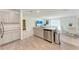 Open concept kitchen featuring stainless steel dishwasher, gray cabinetry and island with view into dining and living area at 3879 E Price Blvd, North Port, FL 34288