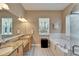 Luxurious bathroom featuring a double sink vanity, soaking tub, and glass-enclosed shower at 426 Islebay Dr, Apollo Beach, FL 33572