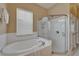 Bathroom with a soaking tub, glass shower, and a window offering plenty of natural light at 426 Islebay Dr, Apollo Beach, FL 33572