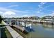 View of boat and lift system at dock with canal and other houses in the background at 426 Islebay Dr, Apollo Beach, FL 33572
