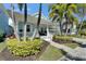 Charming light blue home featuring a welcoming front porch, lush landscaping, and a well-maintained lawn at 426 Islebay Dr, Apollo Beach, FL 33572