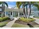 Charming light blue home featuring a welcoming front porch, lush landscaping, and a well-maintained lawn at 426 Islebay Dr, Apollo Beach, FL 33572