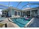 Backyard oasis featuring a sparkling screened-in pool, a seating area, and an outdoor kitchen at 426 Islebay Dr, Apollo Beach, FL 33572