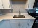 Updated kitchen features white cabinets, subway tile backsplash, stainless steel sink, and quartz countertops at 4316 70Th N Ave, Pinellas Park, FL 33781