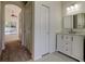 Hallway view leading to bright bathroom with a vanity and marble countertop, plus view to outdoor pool at 476 Denise St, Tarpon Springs, FL 34689