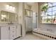 Bright bathroom with a large window, soaking tub, separate shower, and a vanity with marble countertop at 476 Denise St, Tarpon Springs, FL 34689