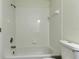 Bright bathroom showcasing the tub with a shower, clean white tile, and modern fixtures at 476 Denise St, Tarpon Springs, FL 34689