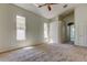 Spacious carpeted bedroom featuring natural light from multiple windows and a ceiling fan at 476 Denise St, Tarpon Springs, FL 34689
