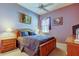 Comfortable purple bedroom with a full-sized bed and side tables at 522 Planters Manor Way, Bradenton, FL 34212