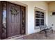 Inviting front entryway featuring a classic door, decorative wreath, and an elegant bench at 522 Planters Manor Way, Bradenton, FL 34212