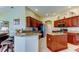 Well-lit kitchen features granite countertops, wood cabinets, stainless appliances, and breakfast bar seating at 522 Planters Manor Way, Bradenton, FL 34212