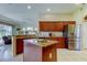Spacious kitchen features an island, wood cabinets, granite counters, and stainless steel appliances at 522 Planters Manor Way, Bradenton, FL 34212