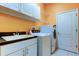 Laundry room featuring a white washer, dryer, storage, and a sink with modern fixtures at 522 Planters Manor Way, Bradenton, FL 34212