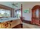 This spacious main bedroom features a four-poster bed, carpeted floor, and sliding glass doors to the pool at 522 Planters Manor Way, Bradenton, FL 34212