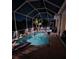 Night view of the pool and outdoor space with enclosed patio at 522 Planters Manor Way, Bradenton, FL 34212