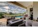 Covered patio with cozy seating overlooking a sparkling pool and green golf course at 522 Planters Manor Way, Bradenton, FL 34212