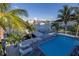 A backyard pool, patio and lounge seating complement the waterfront location with boat dock and canal views at 533 Lillian Dr, Madeira Beach, FL 33708