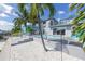 This backyard features a pool, patio, lounge chairs, white gravel and palm trees for waterfront relaxation at 533 Lillian Dr, Madeira Beach, FL 33708